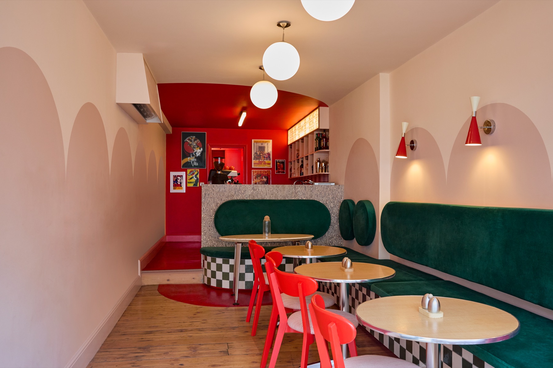 Intervallo Italian cafe interior with red chairs, green velvet banquette and arched walls in Deptford London