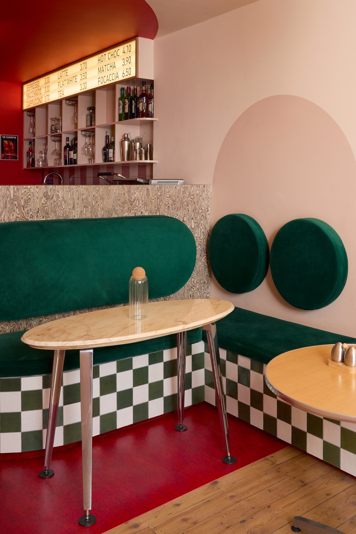 Green velvet banquette booth with marble table at Intervallo Italian cafe Deptford London